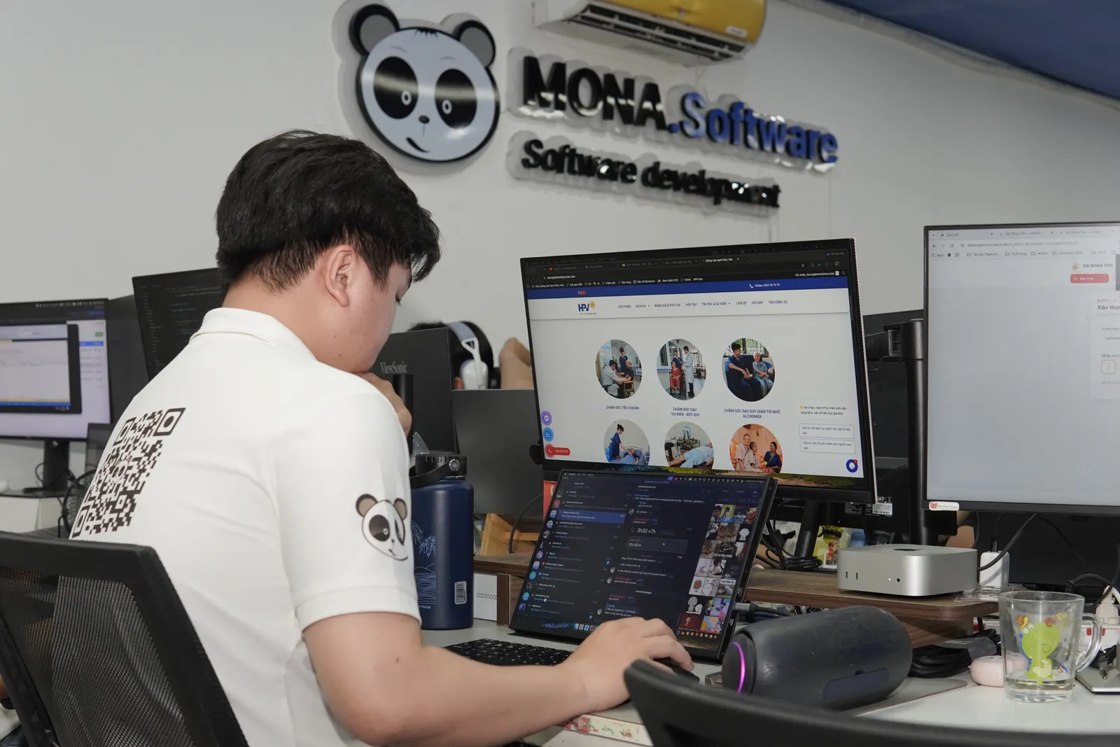 Kỹ sư quay lưng làm việc dưới logo MONA Software